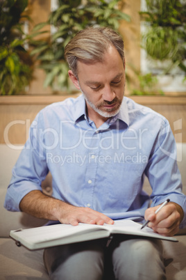 Attentive doctor writing in organizer