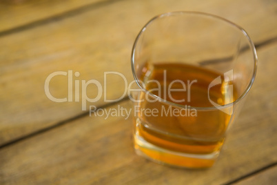 Glass of whisky on wooden table