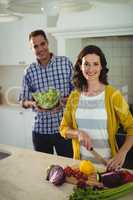 Smiling couple chopping vegetables in the kitchen at home