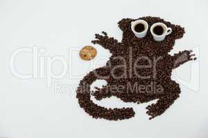 Coffee beans and cups forming monkey with cookie