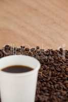 Coffee beans and black coffee in disposable cup