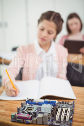 Schoolgirl working on electronic project in classroom