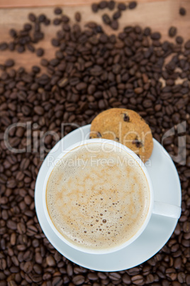 Coffee cup with cookie and coffee beans