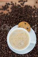 Coffee cup with cookie and coffee beans