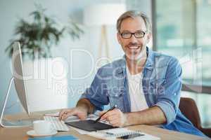 Portrait of male graphic designer using graphics tablet