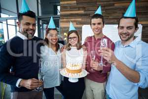 Portrait of businesspeople celebrating their colleagues birthday