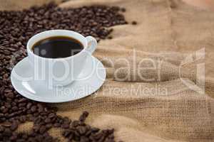 Coffee cup with coffee beans on sack