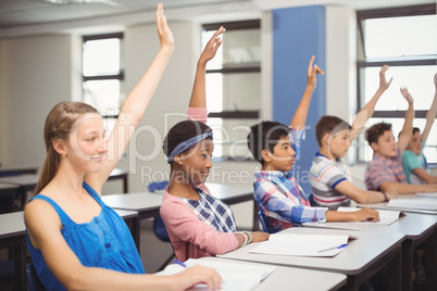 Student raising hand in classroom