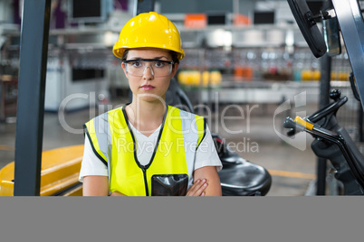 Portrait of female worker standing with arms crossed