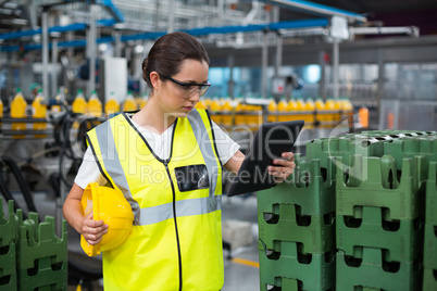 Female factory worker using a digital tablet in factory