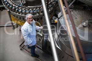 Factory engineer monitoring filled juice bottle on production line