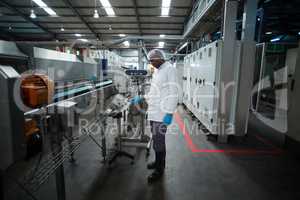 Factory engineer operating machine in factory