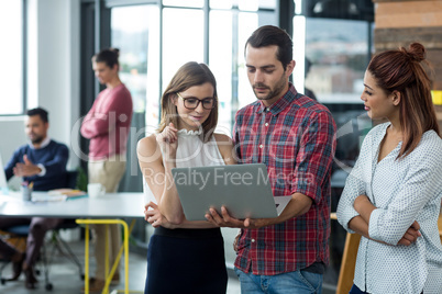 Businesspeople having discussion over laptop