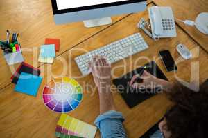 Graphic designer using graphic tablet and desktop