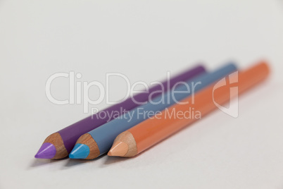 Three colored pencils on white background