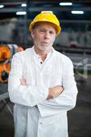 Portrait of factory engineer standing with his arms crossed