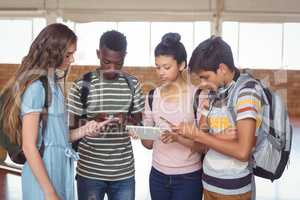 Students using mobile phone and digital tablet in campus