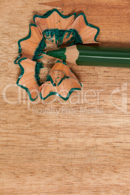 Close-up of green colored pencil with shavings