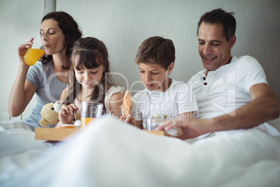 Parents and kids having breakfast in bed