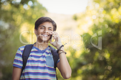 Schoolboy using mobile phone in campus at school