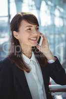 Businesswoman talking on mobile phone at railway station