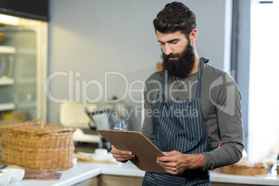 Salesman holding clipboard at counter