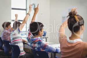 Student raising hand in classroom