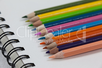 Close-up of colored pencils and notebook