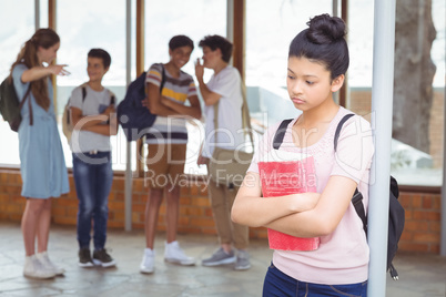 School friends bullying a sad girl in corridor