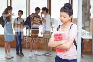 School friends bullying a sad girl in corridor