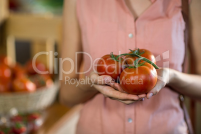 Woman holding tomatoes in grocery store