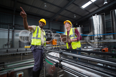 Two factory workers looking up in the factory