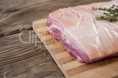 Beef brisket and herb on wooden tray against wooden background