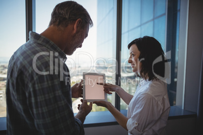 Business executives discussing over digital tablet