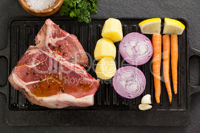 Sirloin chop and ingredients on black grill