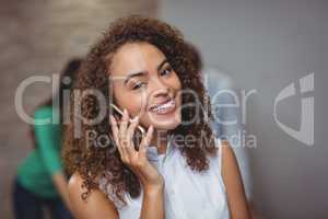 Female executive talking on mobile phone in office