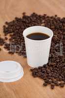 Coffee beans and black coffee in disposable cup