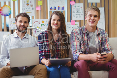 Portrait of graphic designers using mobile phone, laptop and digital tablet