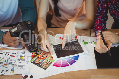 Mid section of graphic designers interacting with each other while working