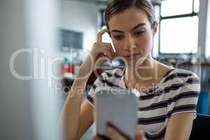 Female graphic designer using mobile phone