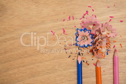 Colored shavings with colored pencils on wooden background