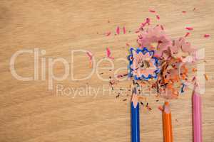 Colored shavings with colored pencils on wooden background