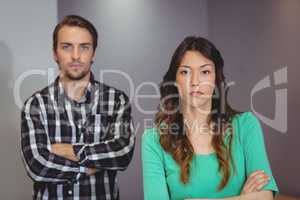 Portrait of male and female business executives standing with arms crossed