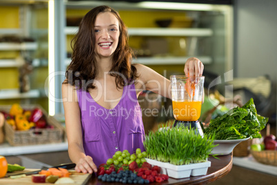 Smiling shop assistant preparing papaya juice