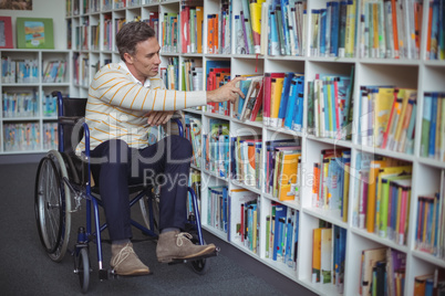 Disabled school teacher selecting book in library