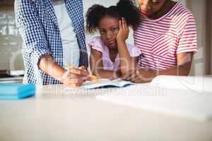 Parents assisting daughter with homework