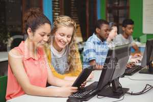 Smiling students studying in computer classroom