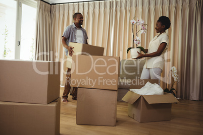 Smiling couple holding card boxes in living room