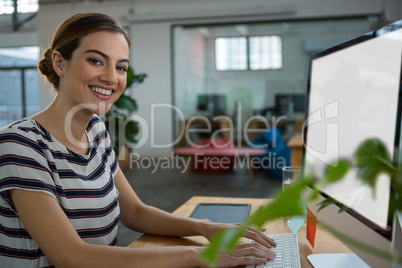 Smiling female graphic designer working on computer