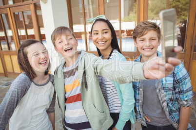 Group of school friends taking selfie with mobile phone